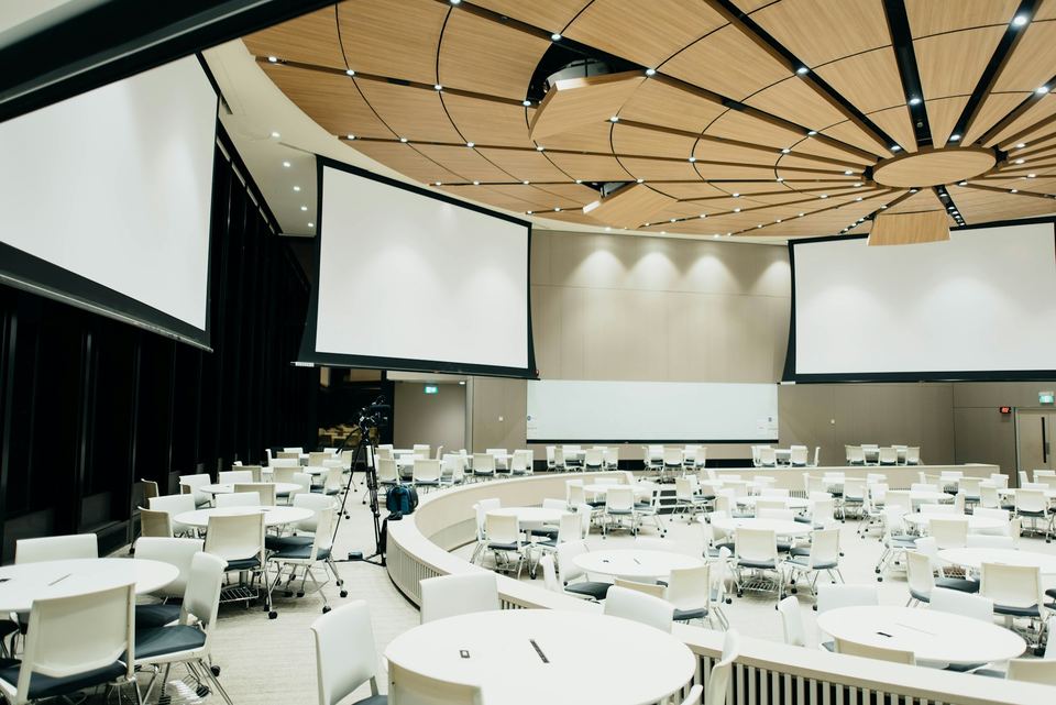 Conference room set with round tables and projection screens