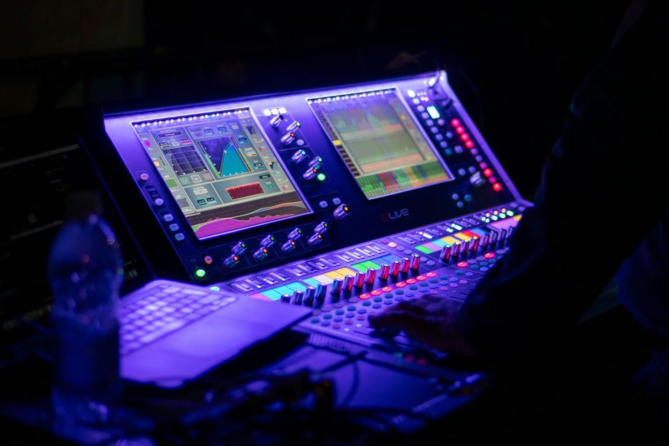 Close-up of a digital mixing console lit in purple