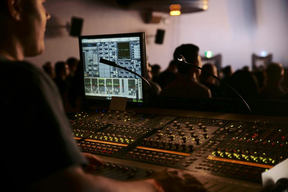 Audio engineer mixing on a large console during a live event