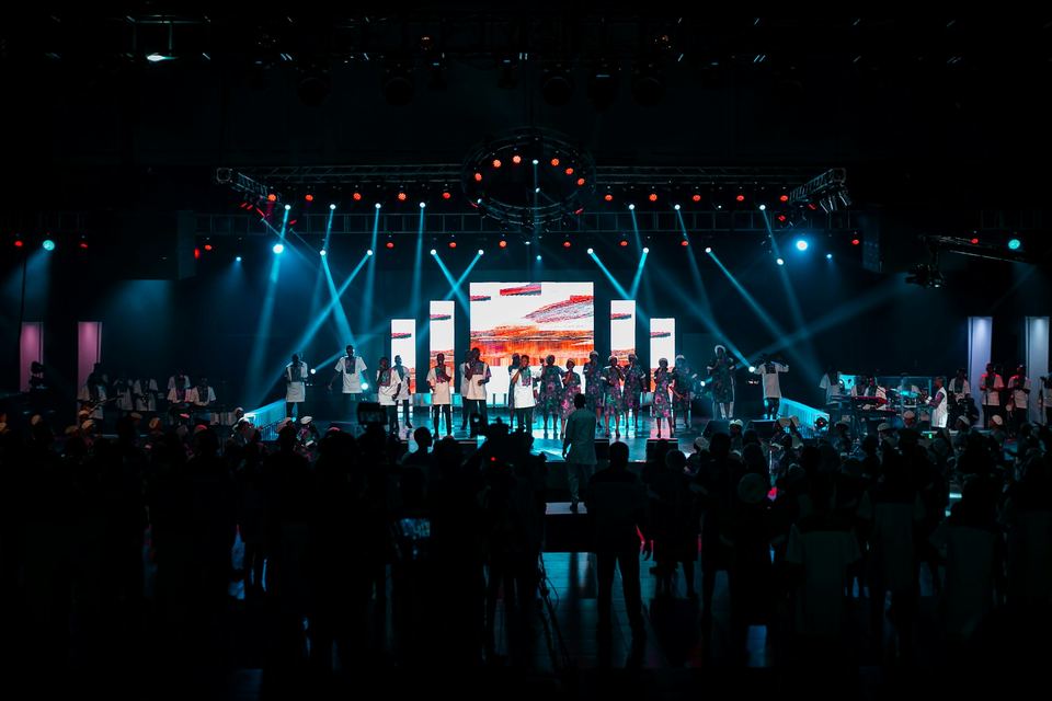 Stage with an LED wall and cyan lighting in front of a large audience