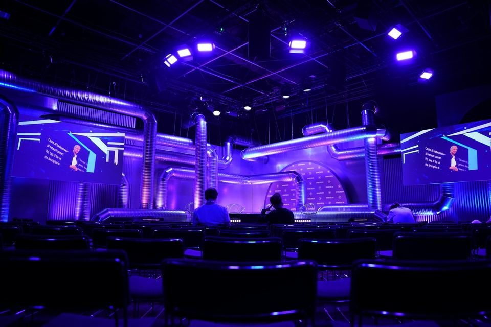 Purple-lit stage with LED screens and audience seating