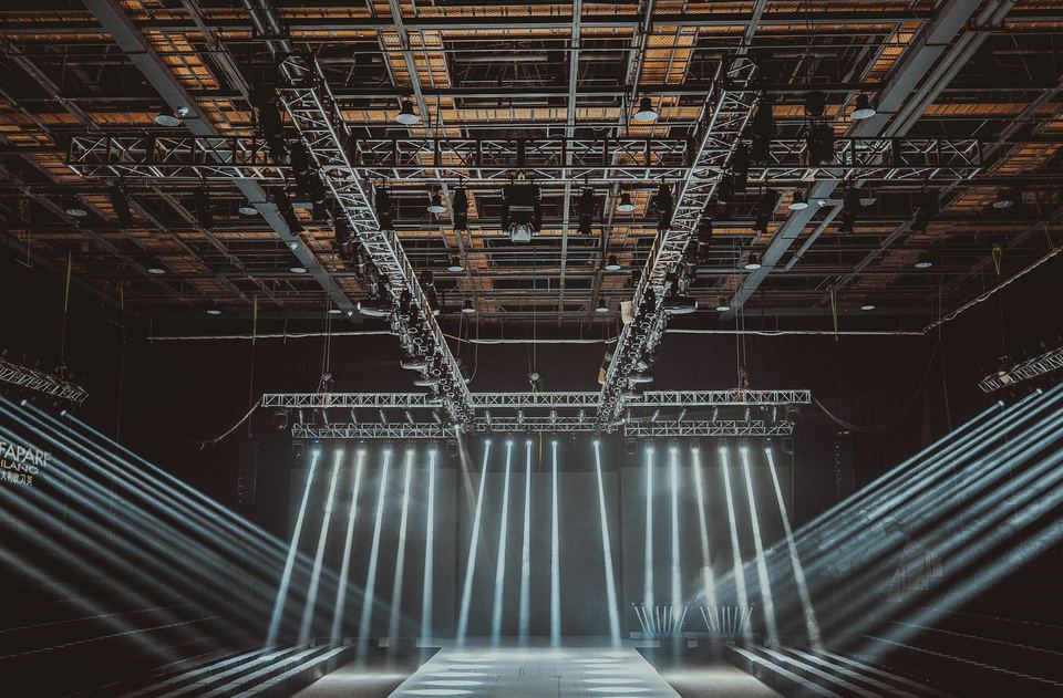Lighting truss rig over a stage, with beams of light below